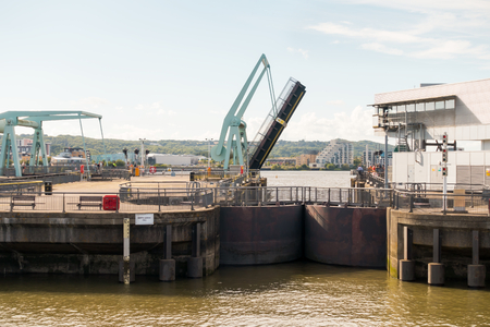 One of the three bascule bridges at the Cardiff Bay barrage is being opened to allow boats out the locks into Cardiff Bay.の写真素材