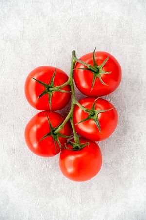 Tomatoes on the vine on gray rough textured background with copy space. Top view.の写真素材
