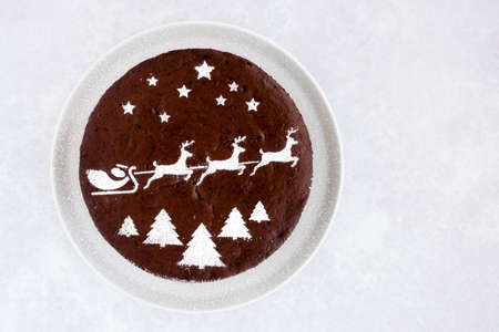 Homemade chocolate cake with Christmas theme on grey background with lots of copy space.の写真素材