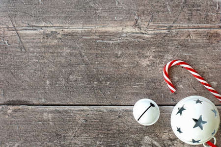 Candy canes, white jingle bell and Christmas Bauble on brown weathered wood. Christmas background.の写真素材