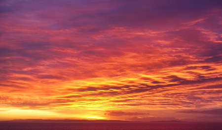 Rare dramatic twilight, fire, sunrise sky in yellow, orange and magenta colors.の写真素材