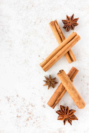 Ceylon cinnamon sticks and star anise on white speckled background with lots of copy space. Top view.の写真素材