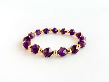 Amethyst bracelet with 8mm Polygonal shaped beads and round gold filled spacer beads isolated on white background. Handmade jewellery. Property release signed by artist.の写真素材