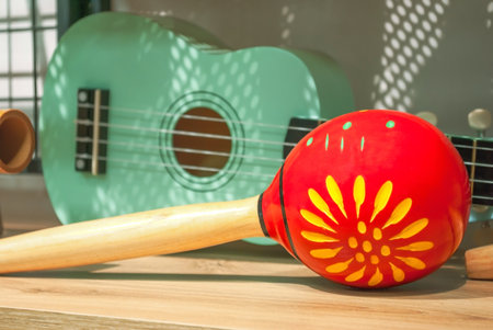 Red maracas and green small Ukulele guitar on wooden shelf sale in shop. Mexican traditional musical instruments set selling in music storeの写真素材