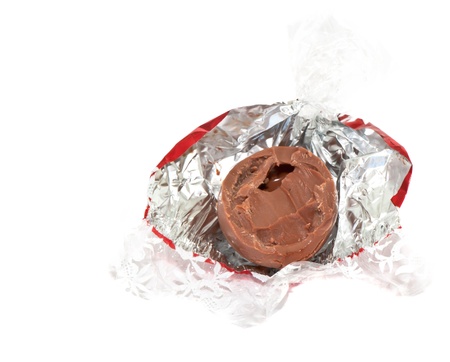 Chocolate candy unwrapped in golden foil isolated on white background
