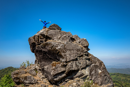 Man stands and raise their hands,Standing on the rocksの写真素材