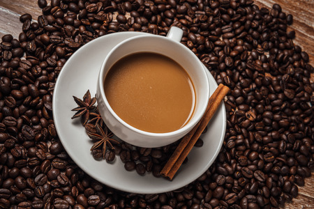 coffee cup with coffee beans,on wood table.の写真素材