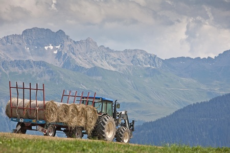 Tractor with trailer and bales of hayの写真素材