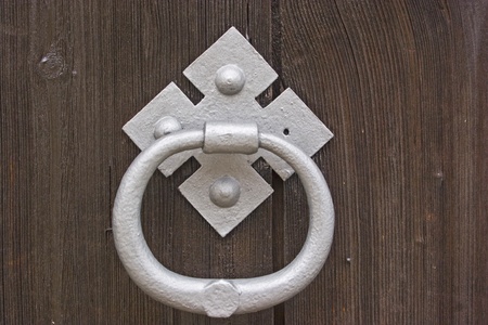 White door knocker on a dark brown wooden background
