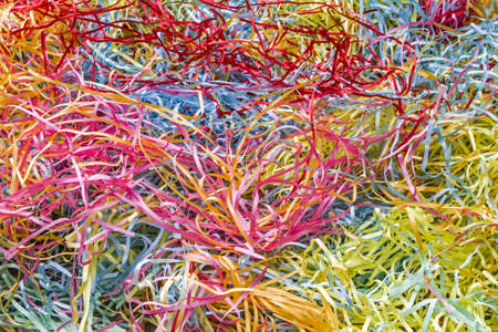Lots of colorful scraps of paper shredded by a shredder