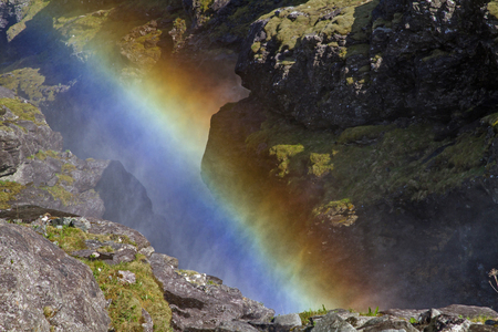 Sun rays which  meet on the fine dust of the waterfall that shine in the glorious colors of the rainbowの写真素材