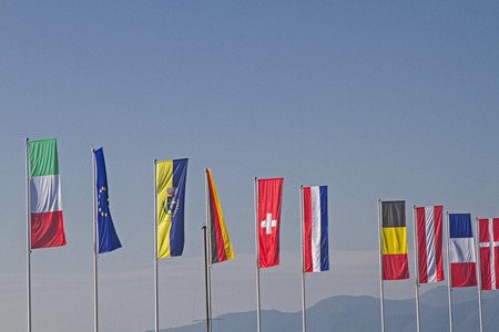 Flags of different countries against blue sky