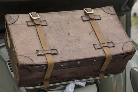View to the rear of a VW Beetle with belted leather suitcase under the rear window