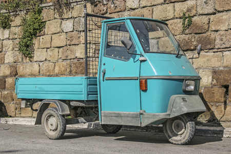 Turquoise tricycle in a narrow Italian alley
