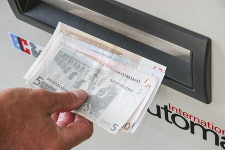 Withdrawal of banknotes at a cash dispenserの写真素材