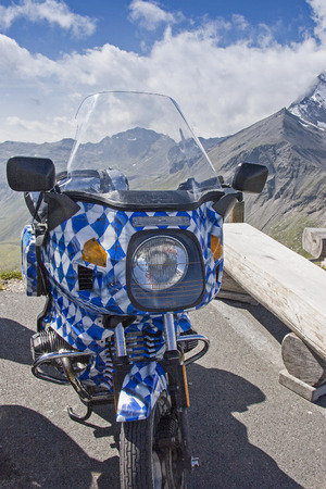 Motorcycle in blue and white diamond pattern on alpine tourの写真素材