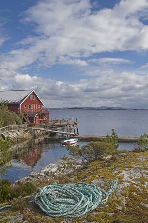 Idyllic red rorbuer on the island Ertvagoy not far from the municipality Aure in Norwayの写真素材