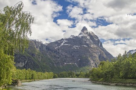 The mighty Romsdalshorn, with its bold silhouette, dominates the scenic Rauma Valley in Norway with the Trolll wall oppositeの写真素材
