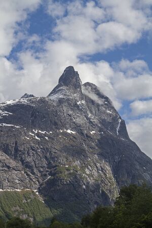 The mighty Romsdalshorn, with its bold silhouette, dominates the scenic Rauma Valley in Norway with the Trolll wall oppositeの写真素材