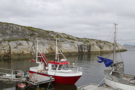 Lonely fishing port with fishing trawler in a bay of the idyllic Lekafjordenの写真素材