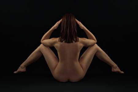 Erotic rear view - classic covert nude against a black backgroundの写真素材