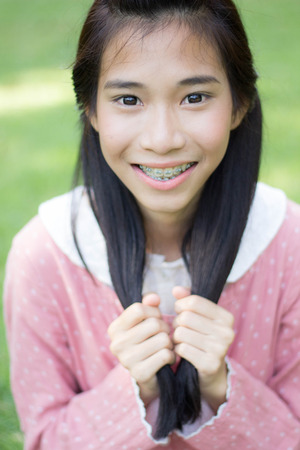 Portrait of thai student teen beautiful girl Dress pink happy and relax On Parkの写真素材