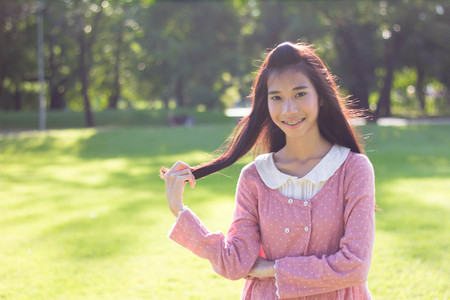 Portrait of thai student teen beautiful girl Dress Pink smile give heart and relax On Parkの写真素材