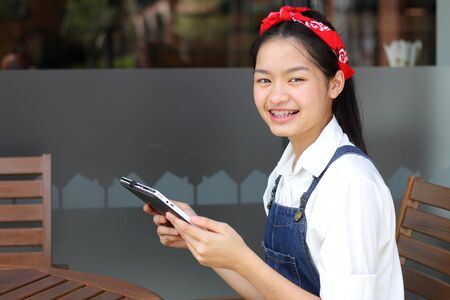 Portrait of thai student teen beautiful girl using her tablet.の写真素材