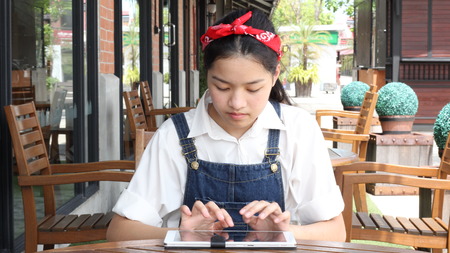 Portrait of thai student teen beautiful girl using her tablet.の写真素材