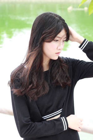 Portrait of thai student teen beautiful girl Black Dresses relax in park.の写真素材
