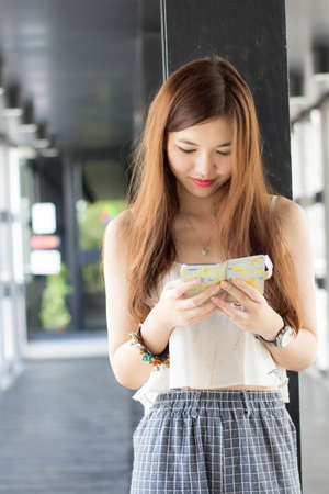 very happy thai adult beautiful girl read message on Smartphone.の写真素材