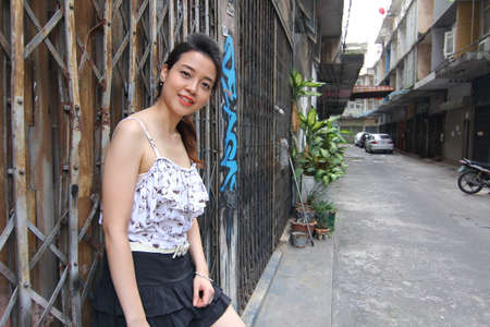 Portrait of thai adult beautiful girl relax and smile on graffiti wallの写真素材