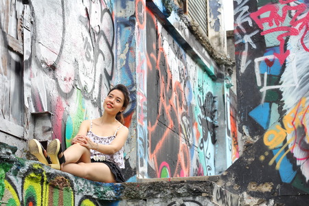 Portrait of thai adult beautiful girl relax and smile on graffiti wallの写真素材
