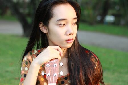 Portrait of thai student teen beautiful girl relax and smile in park.の写真素材
