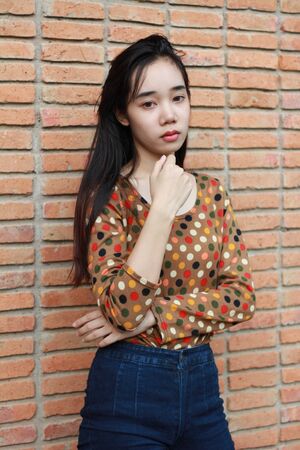 Portrait of thai student teen beautiful girl relax and smile in park.の写真素材