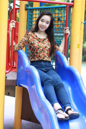 Portrait of thai student teen beautiful girl relax and smile in park.の写真素材