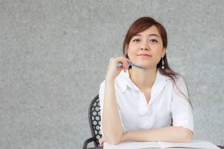 Portrait of thai adult businesswoman beautiful girl write a book.の写真素材