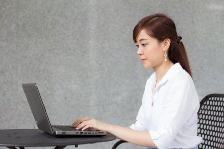 Portrait of thai adult businesswoman beautiful girl using computer notebook.の写真素材