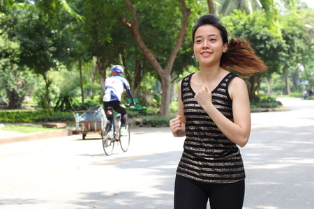 Portrait of thai adult beautiful girl doing running exercises in the park