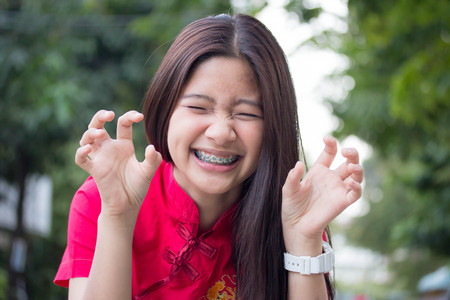 Portrait of thai teen beautiful girl in Chinese dress, relax and smile.