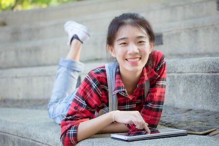 asia thai teenager Women Scotch T-Shirt using her tablet.の写真素材