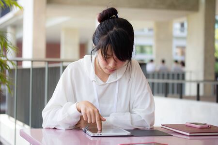 Portrait of thai student university beautiful girl using her tabletの写真素材