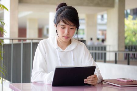 Portrait of thai student university beautiful girl using her tabletの写真素材