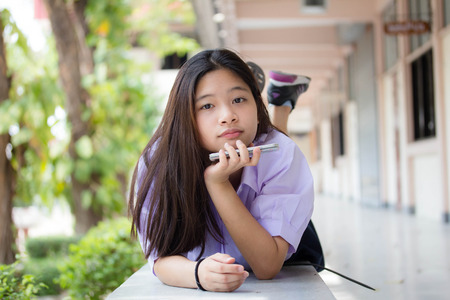 Portrait of thai student High School beautiful girl using her smart phone.の写真素材
