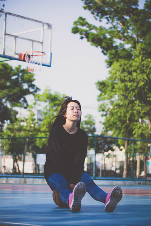 asia thai teenager Women black T-Shirt relax and smile in Basketball courtの写真素材