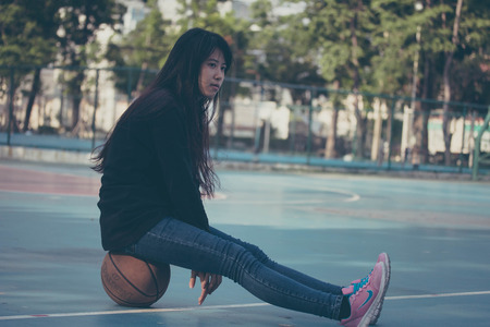 asia thai teenager Women black T-Shirt relax and smile in Basketball courtの写真素材