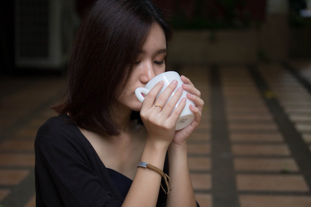 Portrait of thai adult glasses beautiful girl drinking coffeeの写真素材