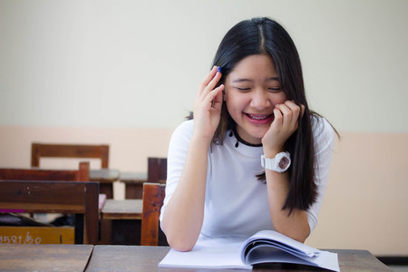 Portrait of thai teen beautiful girl reading bookの写真素材