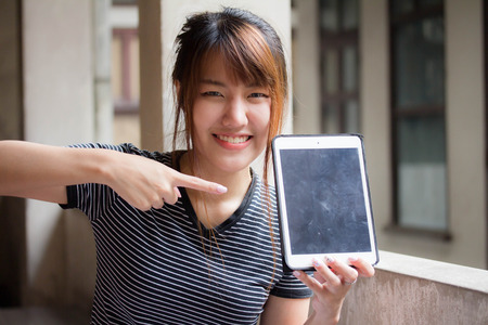 Portrait of thai adult student university beautiful girl using her tablet.の写真素材