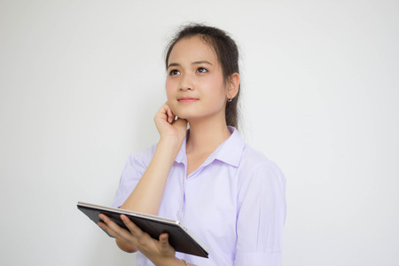Portrait of thai high school student uniform beautiful girl using her tablet.の写真素材